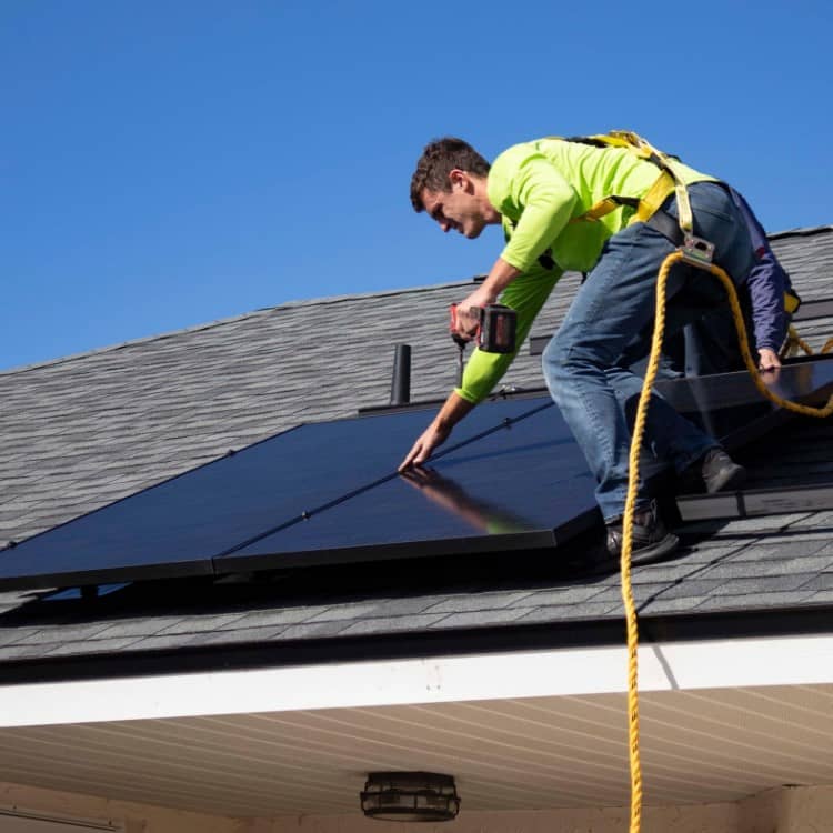 someone working with solar panels on a roof